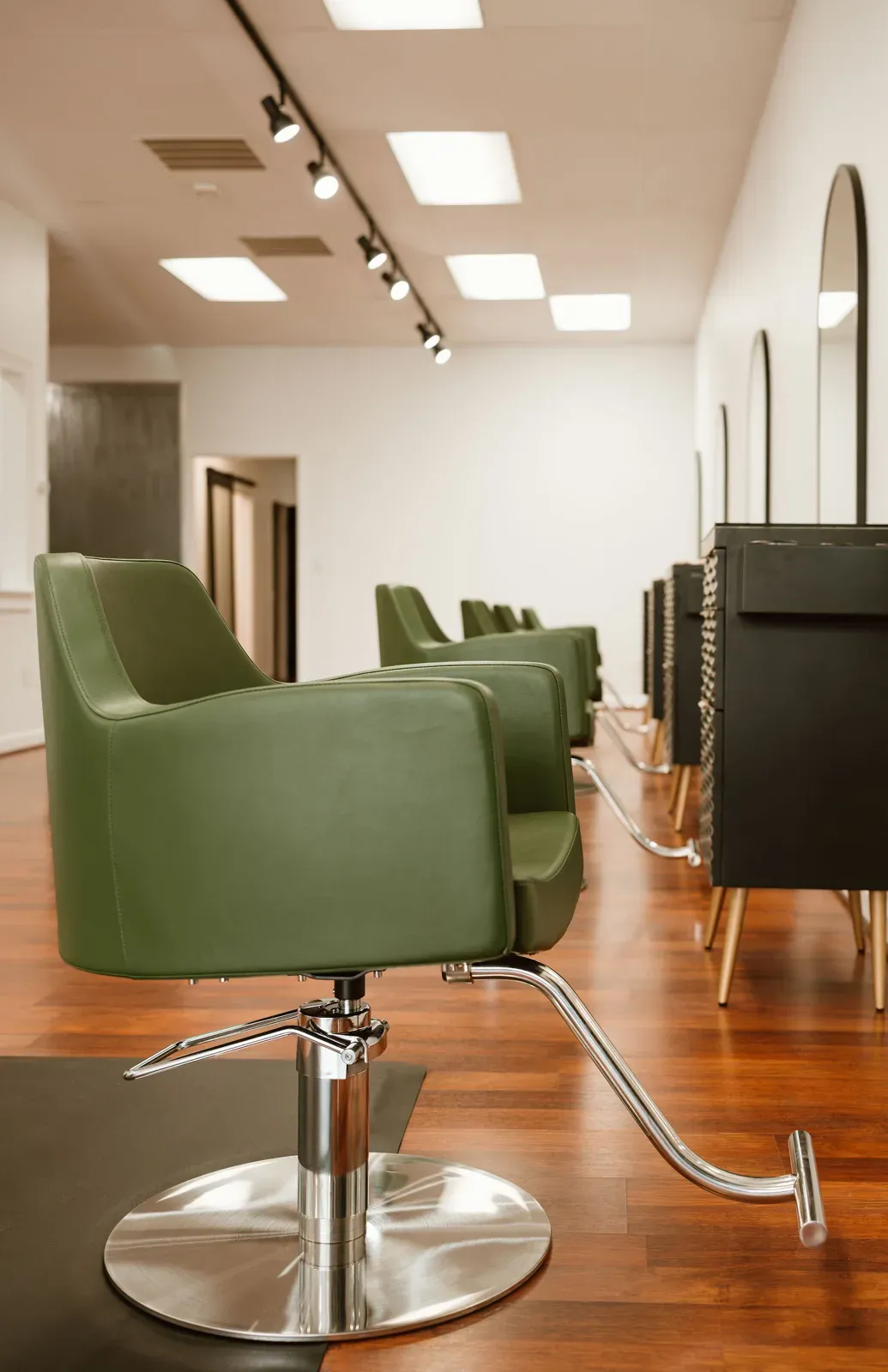 A spruce-green salon chair on a chrome base