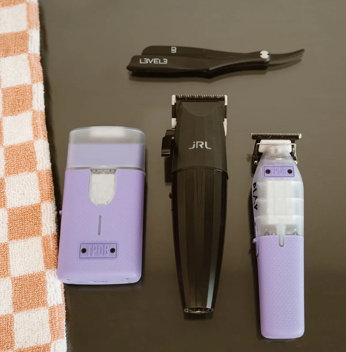 Lavender clippers on a black station beside a checkerboard towel