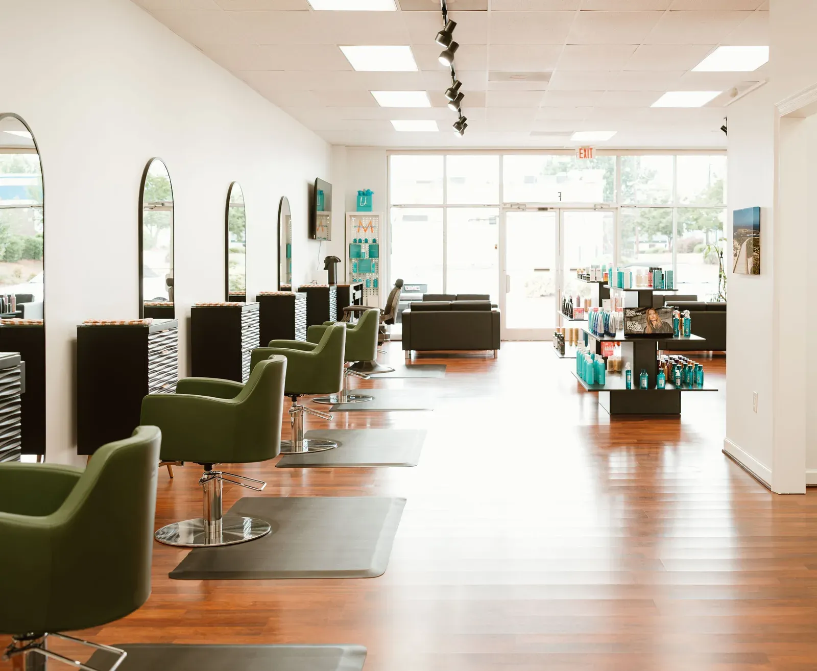 The finished salon floor: green chairs, arched mirrors and warm wood floors