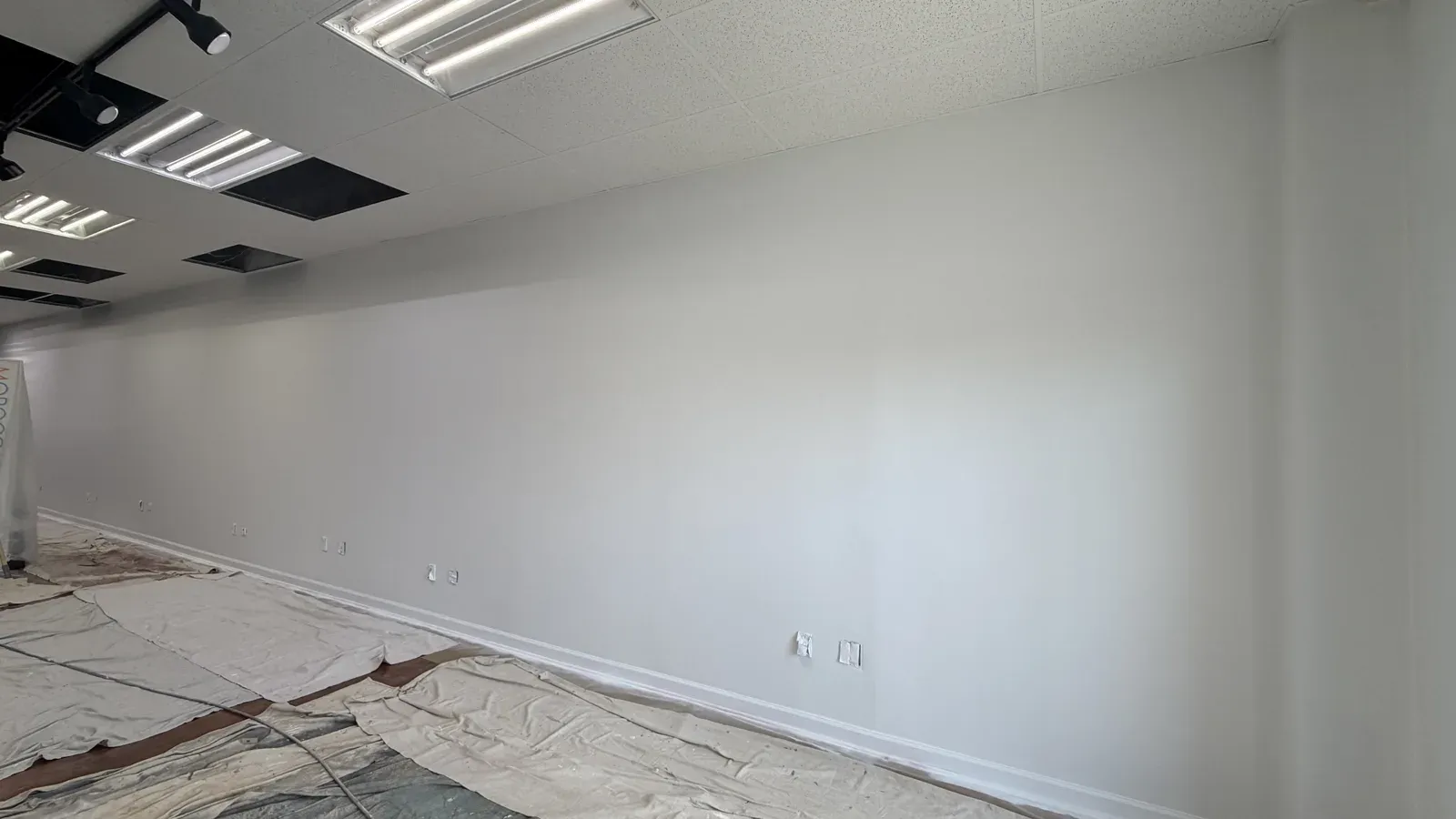 Freshly painted white walls with drop cloths on the floor