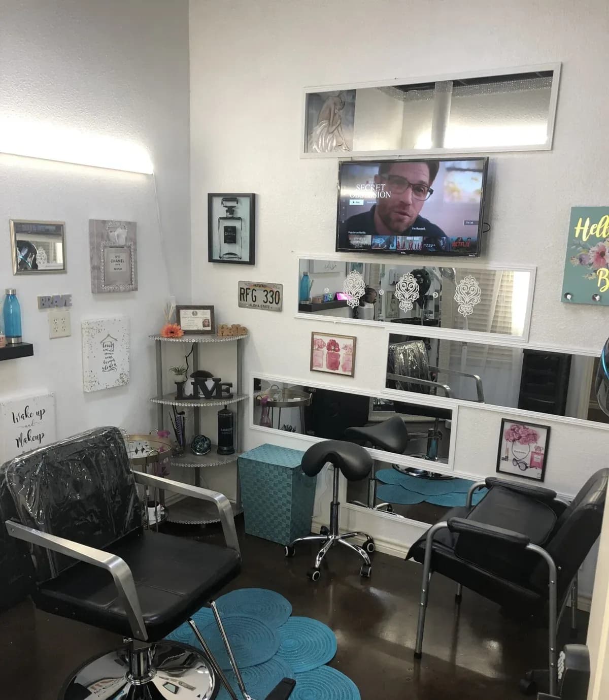 A suite with blue chairs and a mirror by the window