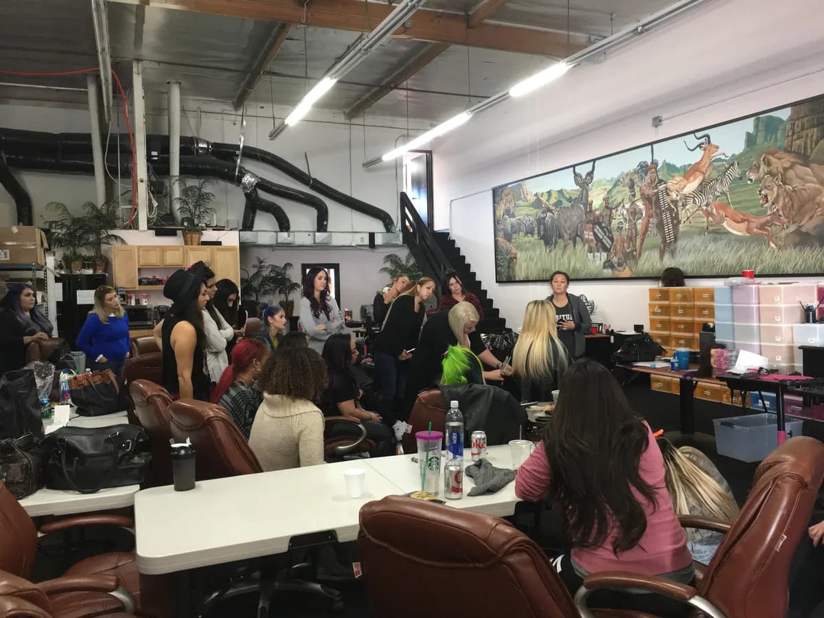 A room of stylists training on mannequin heads at an extension education day