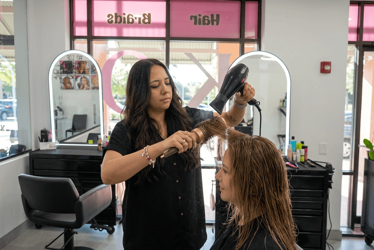 A KC stylist blow-drying a client at the chair