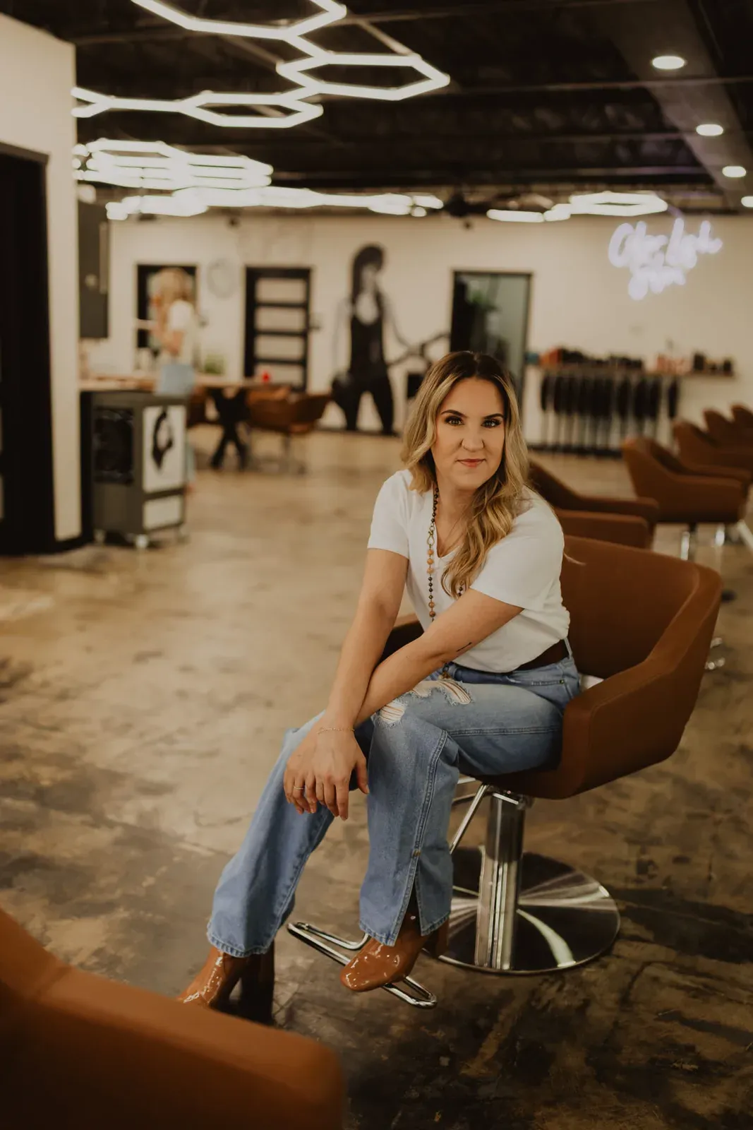 A stylist photographed against the salon’s white brick wall
