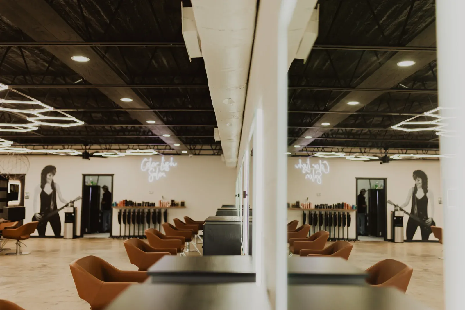 The Color Lush floor: hexagonal LED lights on a black ceiling over cognac leather chairs