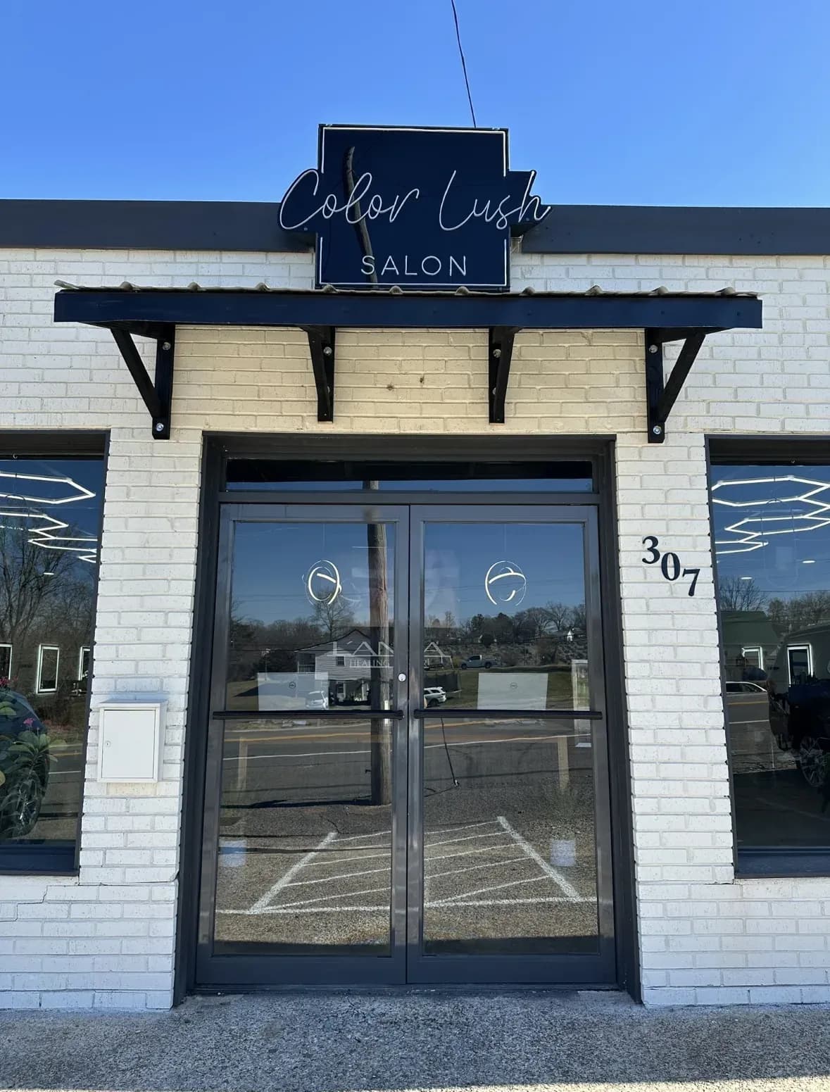 The Color Lush storefront with its script sign on white brick